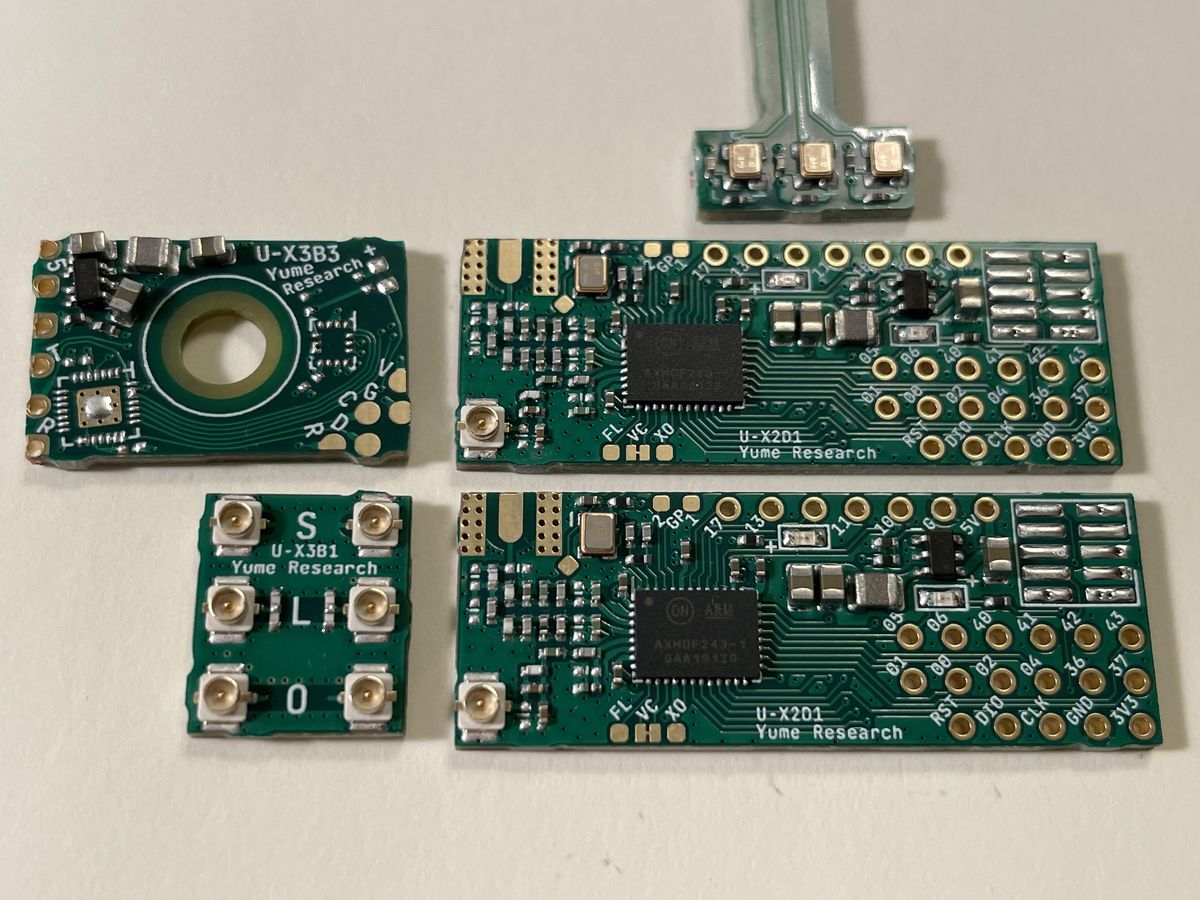 Several small RF modules and a sensor flex board on a white desk